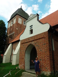 Annerose Neumann vor der Ziegelwand am Eingang zur Passenheimer Kirche Foto: Uwe Hahnkamp
